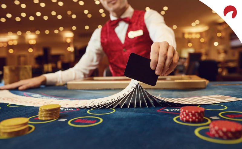 Dealer đang chia bài tại bàn chơi live casino với chip và bài được sắp xếp chuyên nghiệp